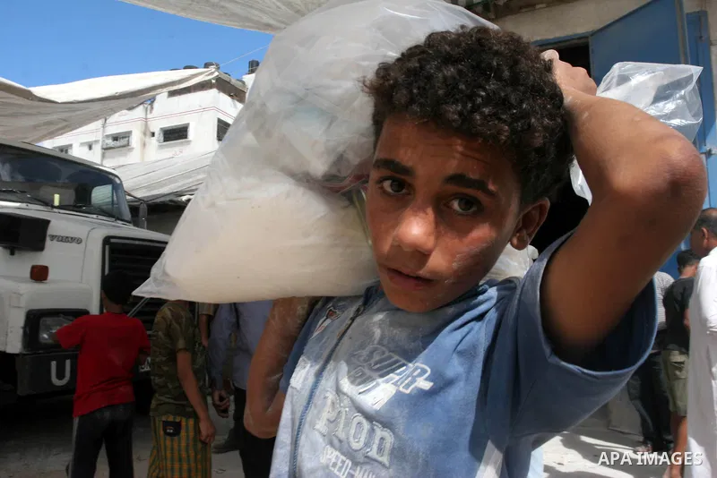 A Palestinian worker carry sack of flour at a United Nations Relief Work Agency depot, in Gaza City on July 14,2009. Photo by Mohammed Asad