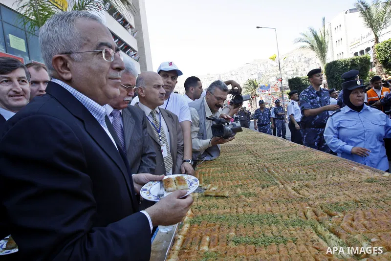 Palestinian prime minister Salam Fayad opens the ceremony of the biggest dish of traditional sweets Konafa into the Guinness Book of Records in the West Bank city of Nablus on July 18 2009. Photo by Photo by Mustafa Abu...