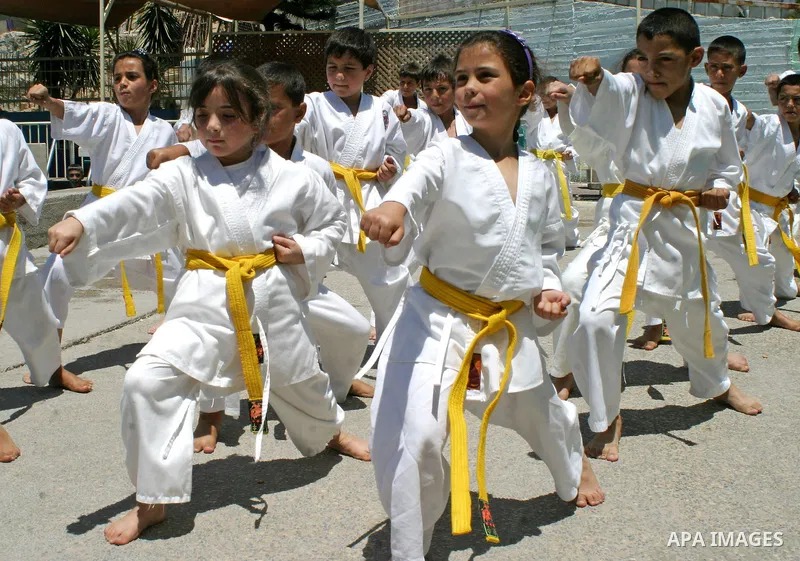 Palestinian children take part in a karate lesson during a summer camp in the West Bank city of Hebron, July 26, 2009. Photo by Najeh Hashlamoun