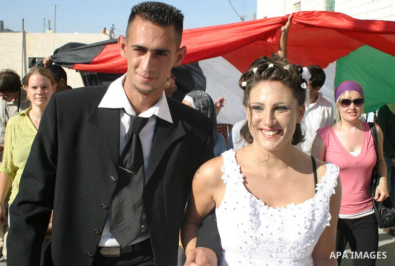 Rami Zuahreh and Rana Zuahreh celebrate their wedding ceremony during a protest against Israel's separation barrier in the West Bank village of Maasarah, near Bethlehem, Friday, July 31, 2009. The couples said they were...