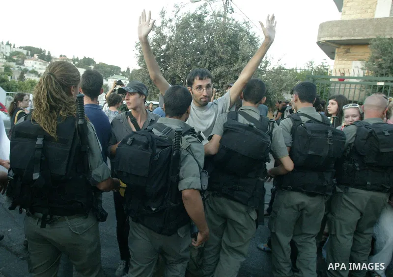 A left-wing Israeli activist is detained by Israeli border police during a protest against the eviction of Palestinians from their homes in Arab east Jerusalem on August 2, 2009. Club-wielding Israeli riot police evicted...