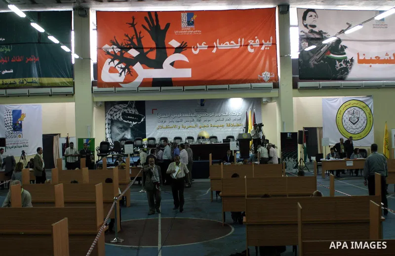 Palestinians walk at the ballot booths for elections to both the Central Committee and the Revolutionary Council as he takes part in the Fatah sixth conference election in the West Bank town of Bethlehem on 09 August 200...