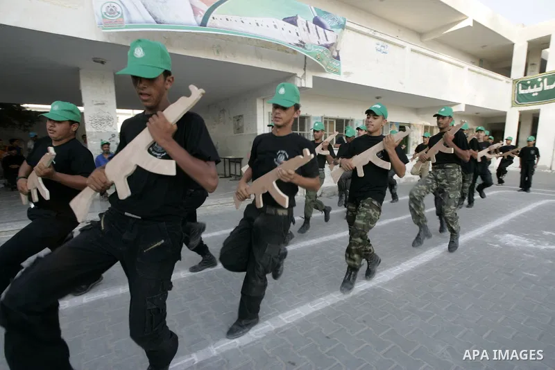 Palestinian boys from a Hamas summer camp exercises in formation with wooden guns in Rafah southern Gaza strip on August 11, 2009. Hamas holds summer camps throughout the Gaza Strip, where participants from 14 to 17 year...
