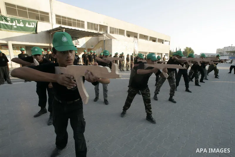 Palestinian boys from a Hamas summer camp exercises in formation with wooden guns in Rafah southern Gaza strip on August 11, 2009. Hamas holds summer camps throughout the Gaza Strip, where participants from 14 to 17 year...