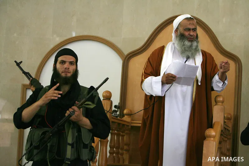 Abdel Latif Musa, a representative the radical Palestinian Islamist group Jund Ansar Allah, is guarded by an armed member of his radical group as he delivers the Friday prayer sermon at a mosque in the southern Gaza Stri...