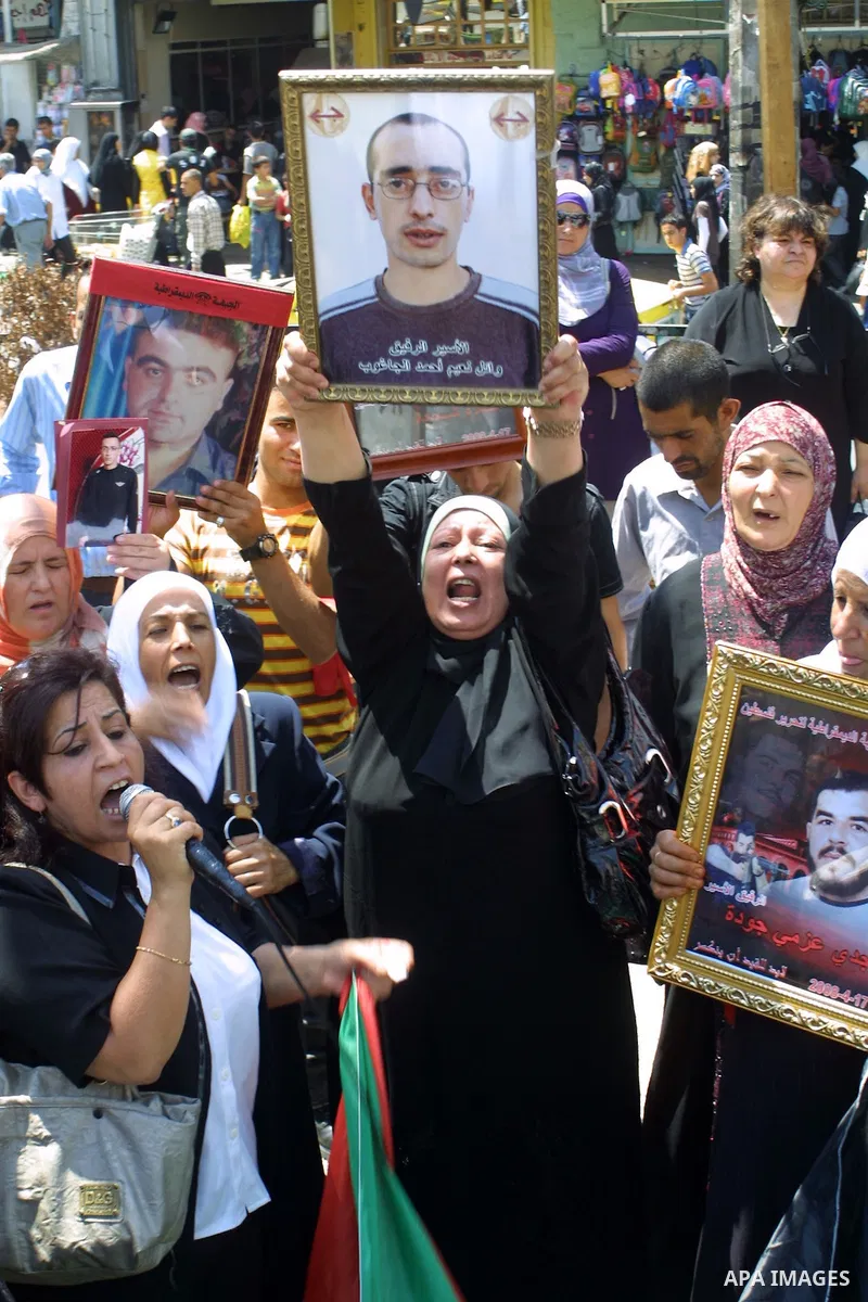 Palestinians hold up pictures of their relatives during a protest in the West Bank city of Nablus calling for the release of Palestinian prisoners from Israeli jails in the west bank city of Nablus on Aug 17, 2009. Photo...