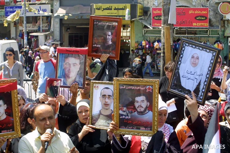 Palestinians hold up pictures of their relatives during a protest in the West Bank city of Nablus calling for the release of Palestinian prisoners from Israeli jails in the west bank city of Nablus on Aug 17, 2009. Photo...