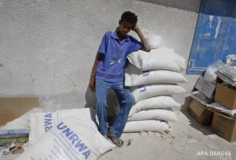 A Palestinian youth carries a sack of flour at a UN Relief and Works Agency (UNRWA) warehouse in the Shati refugee camp, in Gaza City, on August 18, 2009. UNRWA launched Monday its Gaza Ramadan Appeal for 181 million dol...