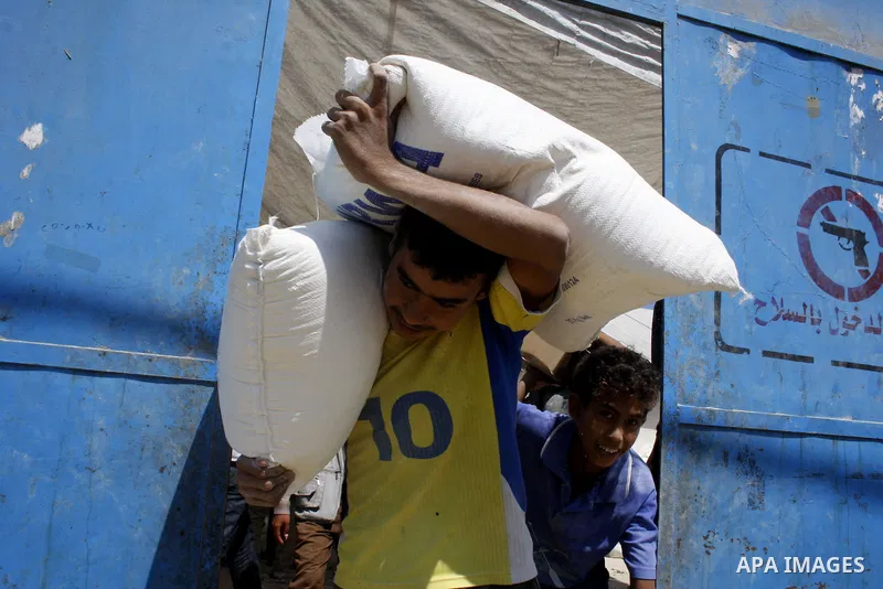 A Palestinian youth carries a sack of flour at a UN Relief and Works Agency (UNRWA) warehouse in the Shati refugee camp, in Gaza City, on August 18, 2009. UNRWA launched Monday its Gaza Ramadan Appeal for 181 million dol...