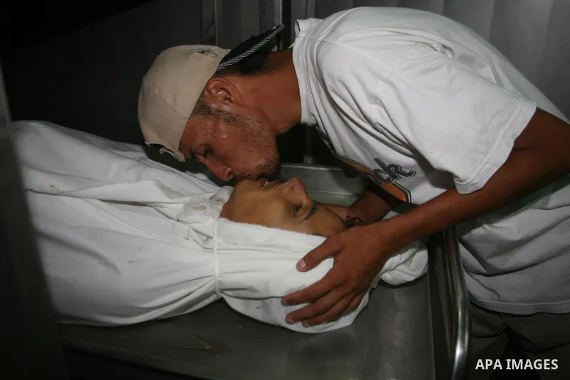 A Palestinian youth says a final farewell to a Palestinian killed by Israeli fire in the town of Beit Lahia in the northern of Gaza Strip on August 24, 2009. One Palestinian man was killed and another wounded by Israeli...
