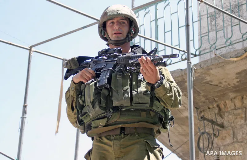 An Israeli soldiers take a positions after Palestinian man who tried to attack a soldier with a knife at an Israeli checkpoint near the Jewish settlements of Beit Hadasa and Tal Rumeida, in the West Bank city of Hebron A...