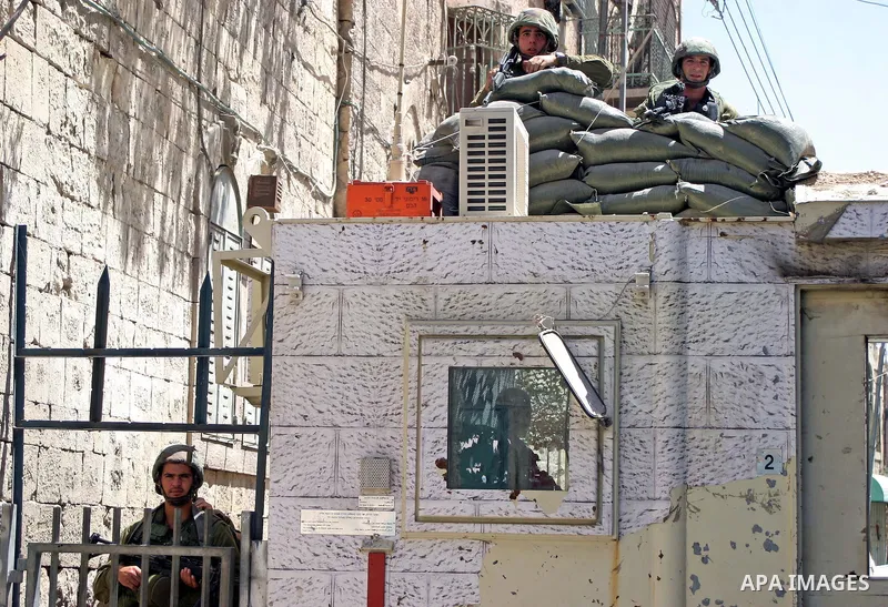 An Israeli soldiers take a positions after Palestinian man who tried to attack a soldier with a knife at an Israeli checkpoint near the Jewish settlements of Beit Hadasa and Tal Rumeida, in the West Bank city of Hebron A...
