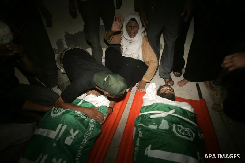 Relatives of Palestinian brothers Mansur and Wael al-Batniji mourn during their funeral in Rafah in the southern Gaza Strip on August 26, 2009. The two Palestinian men and their third brother Ibrahim were killed and nine...