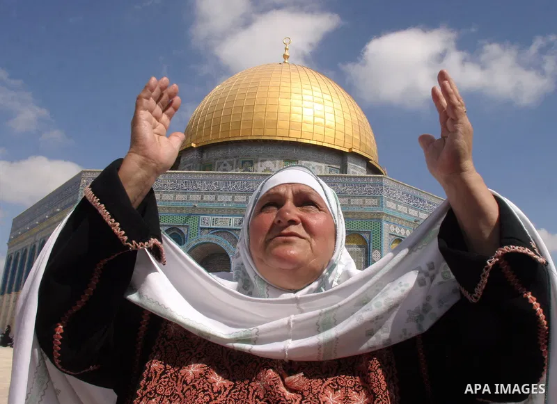 A Palestinian woman prays on the first Friday of the Muslim holy month of Ramadan in front of the Dome of the Rock on the compound known to Muslims as al-Haram al-Sharif (Noble Sanctuary) and to Jews as Temple Mount, in...