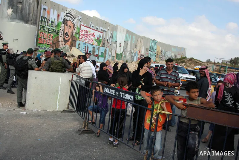 A Palestinians wait to cross an Israeli checkpoint of Qalandiya near the West Bank city of Ramallah on Aug 28, 2009, as they try to reach the al-Aqsa mosque in Jerusalem on the first Friday of the Muslim holy month of Ra...