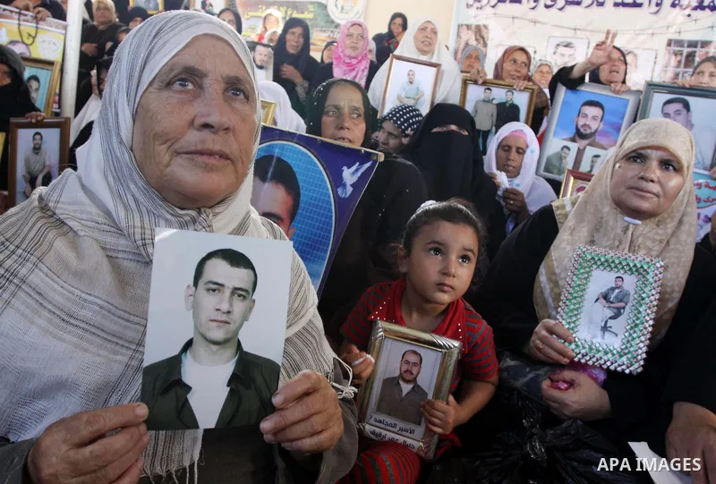 Palestinians hold pictures of their relatives jailed in Israeli prisons during a protest in Gaza City on August 31, 2009 to call for their release. Currently Israel is holding 11,000 Palestinians in its jails. Photo By M...