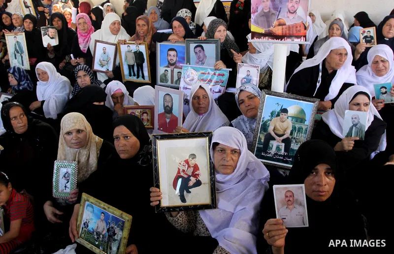 Palestinians hold pictures of their relatives jailed in Israeli prisons during a protest in Gaza City on August 31, 2009 to call for their release. Currently Israel is holding 11,000 Palestinians in its jails. Photo By M...