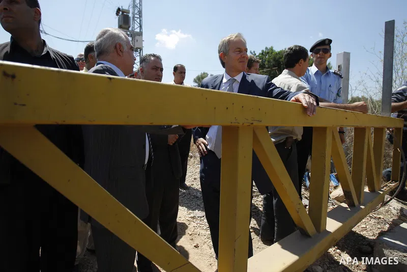 Middle East Quartet envoy and former British Prime Minister Tony Blair gestures during his visit to a part of the controversial Israeli "separation wall" before a meeting with Palestinian businessmen and officials in the...