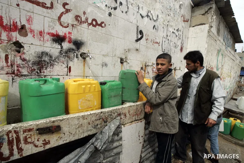 A palestinians fill their canisters by a potable water at water purification station in Rafah town in southern Gaza Strip on Sep 6,2009.Palestinians face dire water shortages because of both bad Palestinian management an...