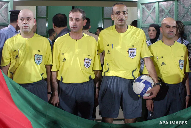 Referees pose for a photograph during Palestinian Olympic team and Jordanian Olympic team during a friendly game at Al-Hussein stadium during the opening ceremony of a new football field in the West Bank city of Hebron,...