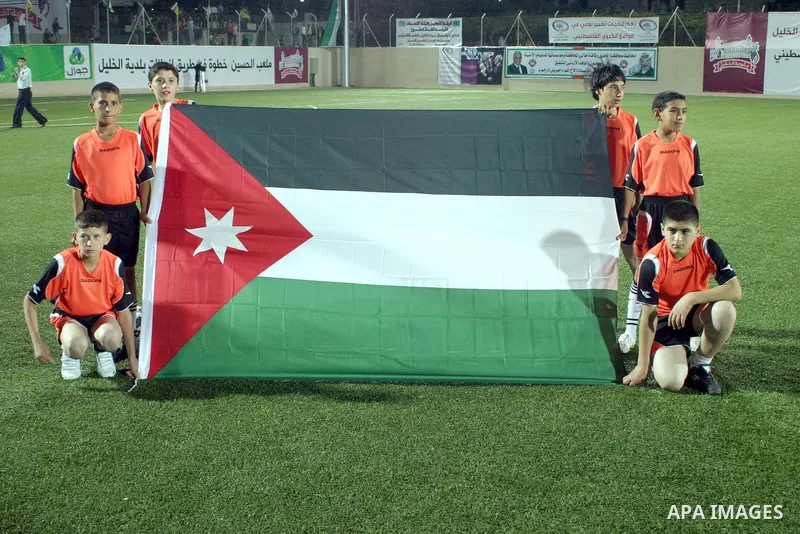 Palestinian children carrying Jordan Flag during Palestinian Olympic team and Jordanian Olympic team during a friendly game at Al-Hussein stadium during the opening ceremony of a new football field in the West Bank city...