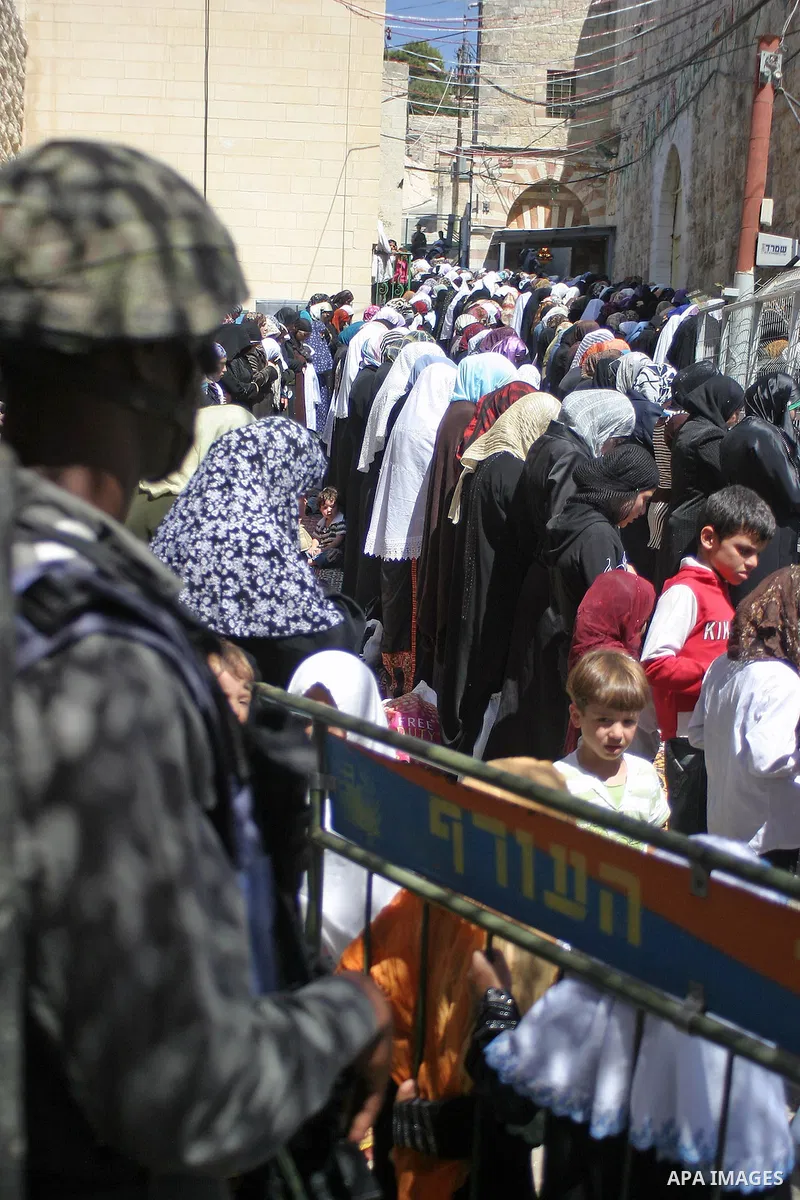 An Israeli border policeman stands guard as Palestinians pray during the third Friday prayers of the Muslim fasting month of Ramadan at the Ibrahimi Mosque in the West Bank city of Hebron on September 11, 2009. During Ra...
