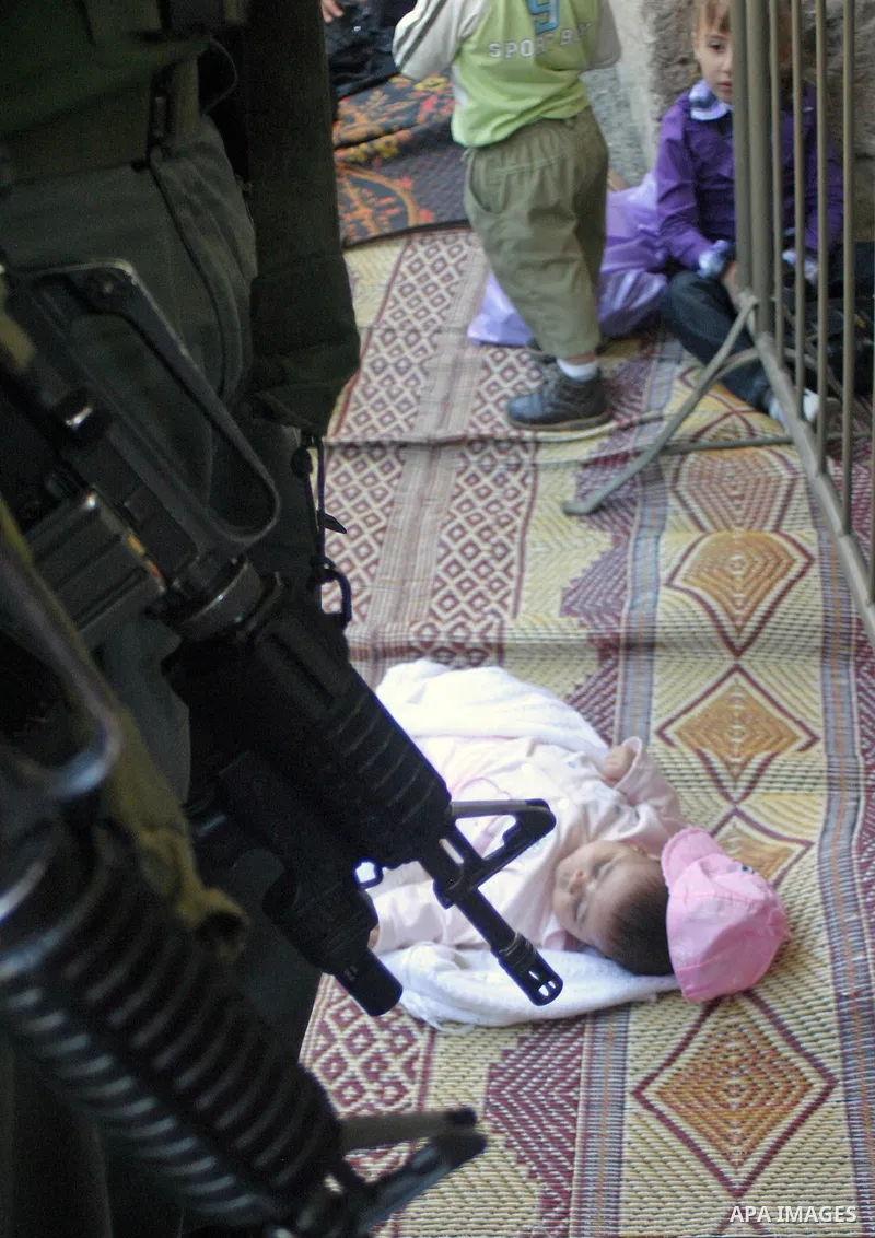 An Israeli border policeman stands guard as Palestinians pray during the third Friday prayers of the Muslim fasting month of Ramadan at the Ibrahimi Mosque in the West Bank city of Hebron on September 11, 2009. During Ra...