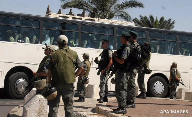 Israeli soldiers stand guard as Palestinian Muslim worshippers cross to Jerusalem to attend the third Ramadan Friday prayers at Al-Aqsa mosque in the old city on September 11, 2009. Thousands of faithful Palestinians are...