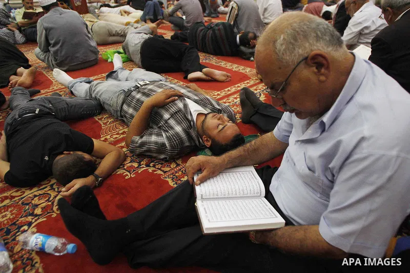 Muslim worshippers pray and read koran in the Al-Aqsa Mosque compound in Jerusalem's Old City during the Islamic anniversary Lailat al-Qader, also known as the Night of Power, late on September 16, 2009. Lailat al-Qader...