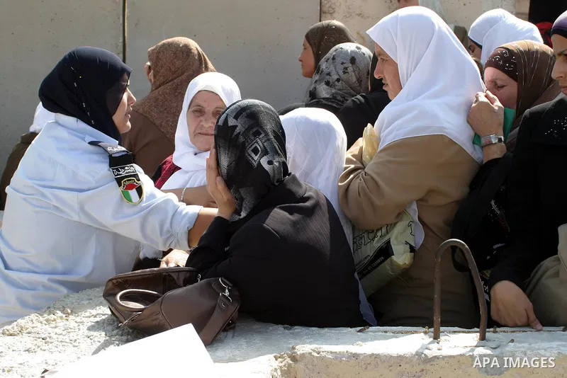 An Palestinian police woman stands guard as Palestinian women on their way to Jerusalem wait in queue at an Israeli controlled checkpoint in the West Bank city of Bethlehem on 18 September 2009. Faithful Palestinian Musl...