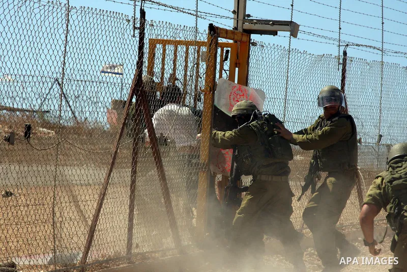 An Israeli soldier detains a demonstrator during a protest against the controversial Israeli barrier in the West Bank village of Bilin near Ramallah on Sep 25, 2009. Photo by Issam Rimawi