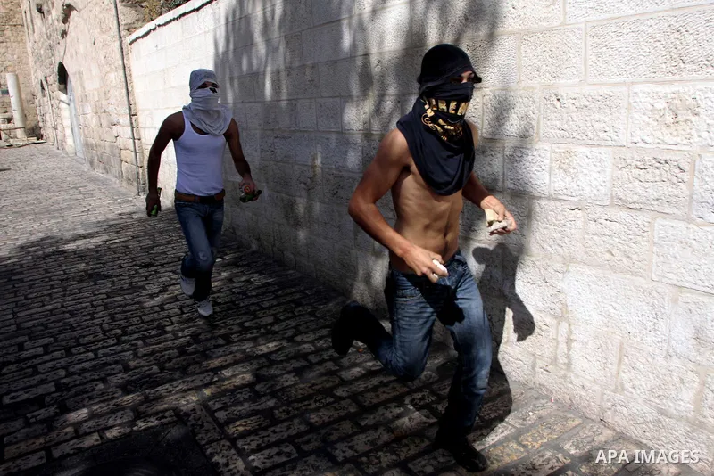 Masked Palestinians hurl stones at Israeli Border Police during clashes between Israeli police and Palestinians in Jerusalem's Old City on Sep 27, 2009. Israeli police used stun grenades to disperse Palestinian rioters a...