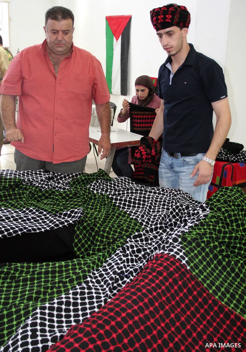 Palestinian designers and tailors display some of the hand-knitted pieces that will be sewn on a the largest traditional Palestinian dress in an attempt to enter the Guinness World Records in the West Bank city of Hebron...