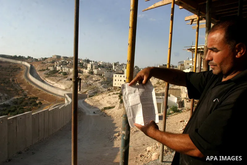 palastenian Labourers stands near the contrevesial wall in the west bank veledge of abu dis 30september2009./photo by MAHFOUZ ABU TURK.