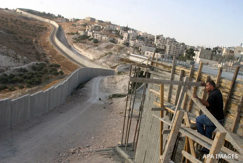 Palestinian Labourer stands near the controversial Israeli separation barrier in the West Bank village of Abu Dis on Sep 30,2009. Photo by Mahfuz Abu Turk