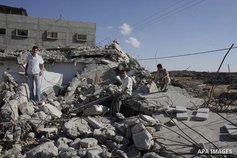 Palestinians men in their house that was destroyed in January's Israeli military offensive, in Jebalia in the northern Gaza Strip, on October 1, 2009. Israel warned that the UN Human Rights Council would strike a fatal b...