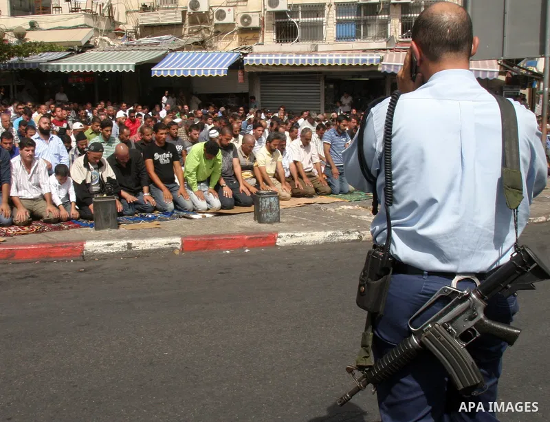 Palestinian worshippers who were prevented from reaching the Al-Aqsa Mosque compound pray in front Israeli border police in Jerusalem on October 2, 2009. Israeli police restricted the entrance age to the Al Aqsa mosque c...