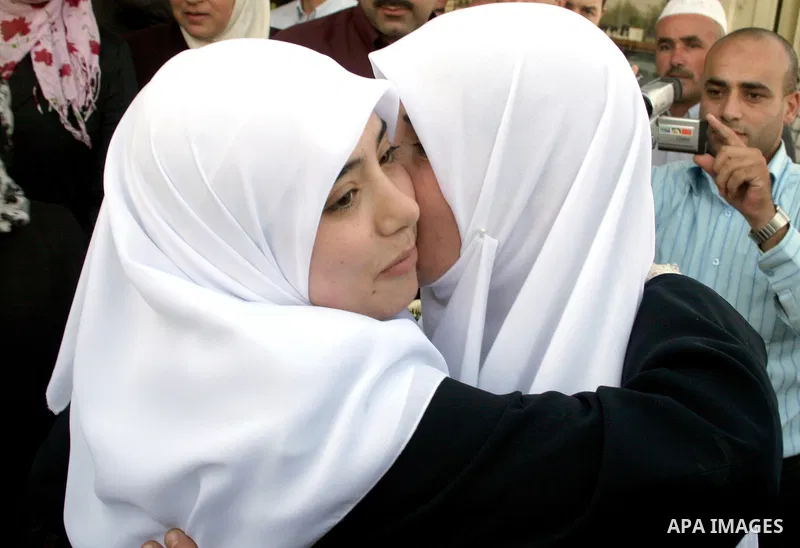 Palestinian women hug her newly released prisoner daughter Hiba al-Natsheh (L) during her arrival following her release from an Israeli prison on October 02, 2009 in the West Bank city of Hebron. Israel received footage...