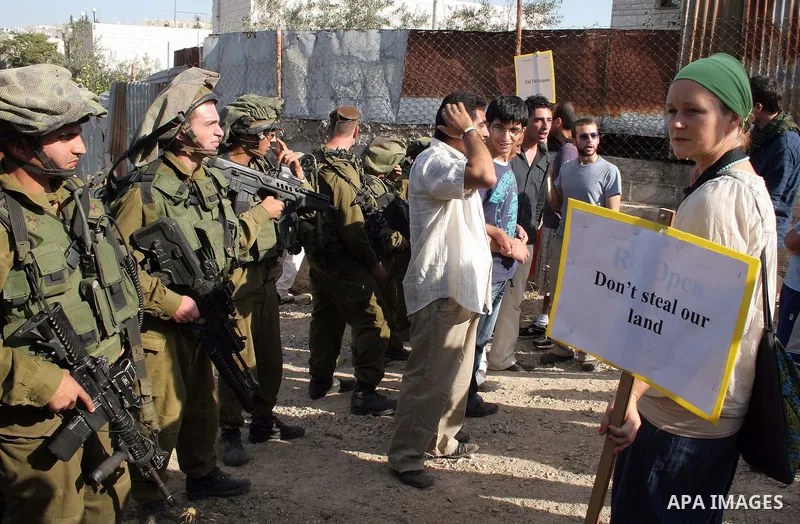 Palestinians, Israelis and foreign activists attend a protest against Jewish settlement within the West Bank near Kiryat Arba settlement in the West Bank city of Hebron October 23, 2009. Photo by Najeh Hashlamoun