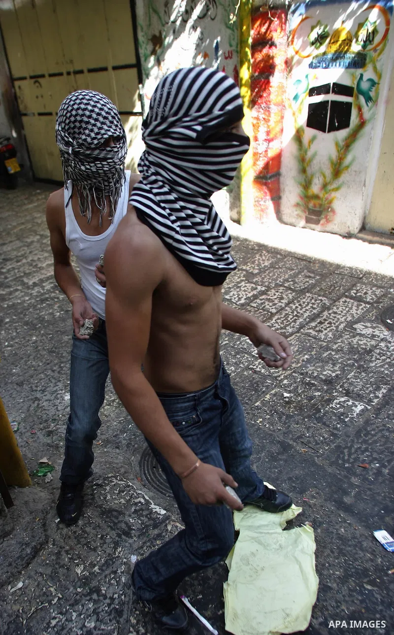 A masked Palestinian youths prepare to hurl stones at the Israeli riot policemen during clashes in Jerusalem's old city on October 25, 2009. Clashes erupted between Israeli police and Palestinians in and around the Al-Aq...