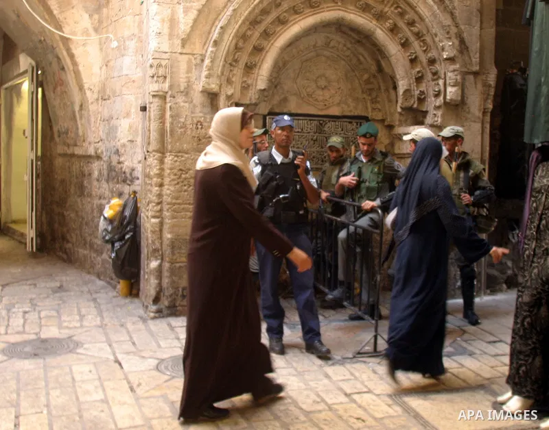 Palestinian women walk past Israeli police officers patrol in Jerusalem's Old City, Monday, Oct. 26, 2009. Hundreds of Israeli police patrolled Jerusalem's most volatile holy site on Monday, a day after fierce clashes wi...
