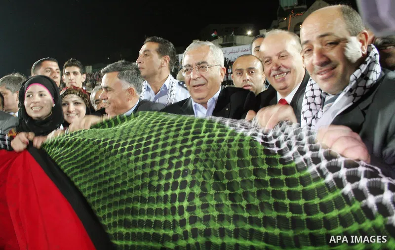 Palestinian Prime Minister Salam Fayyad during display the largest traditional Palestinian dress it will be to create the largest traditional Palestinian dress in an attempt to enter the Guinness World Records at Al-Huss...