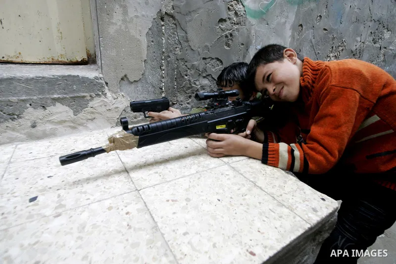 A Palestinian boys play with toy guns to celebrate Eid Al-Adha on the third day in the Rafah Refugee Camp in the southern Gaza Strip on November 29, 2009. Muslims worldwide are celebrating Eid al-Adha or Feast of the Sac...