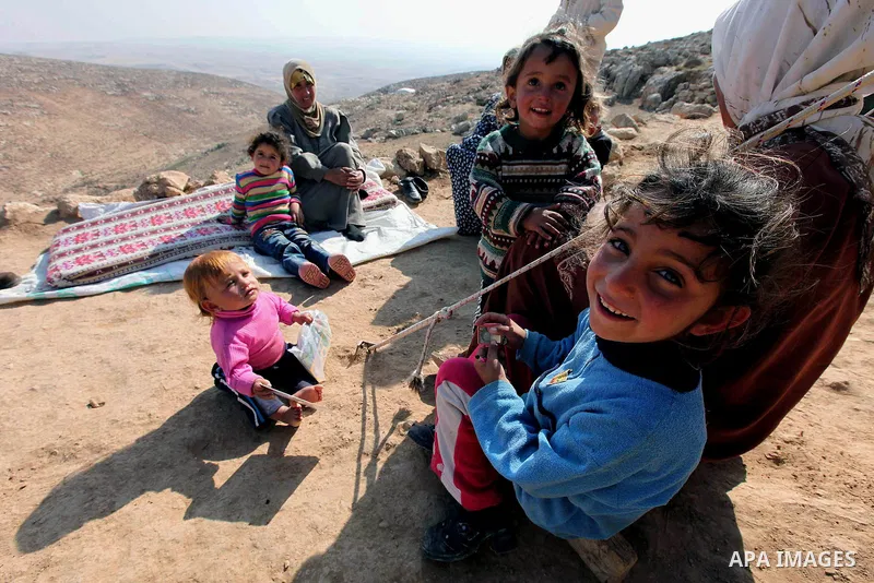 Palestinian women and children sit outside tents in a mountainous area outside the southern town of Yatta near Hebron in the occupied West Bank on December 5, 2009. Palestinian residents of the area have returned to thei...