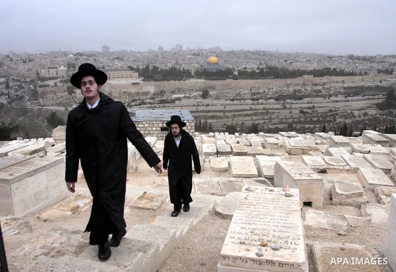 Ultra-Orthodox Jews are seen at the Jewish cemetery on the Mount of Olives in Jerusalem on Dec 7, 2009. The Dome of the Rock on the compound known to Muslims as al-Haram al-Sharif, and to Jews as Temple Mount, is seen in...