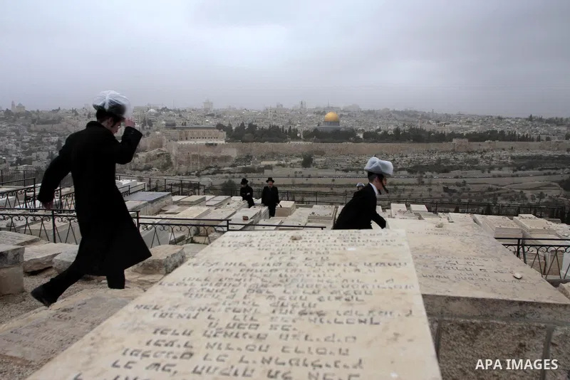 Ultra-Orthodox Jews are seen at the Jewish cemetery on the Mount of Olives in Jerusalem on Dec 7, 2009. The Dome of the Rock on the compound known to Muslims as al-Haram al-Sharif, and to Jews as Temple Mount, is seen in...