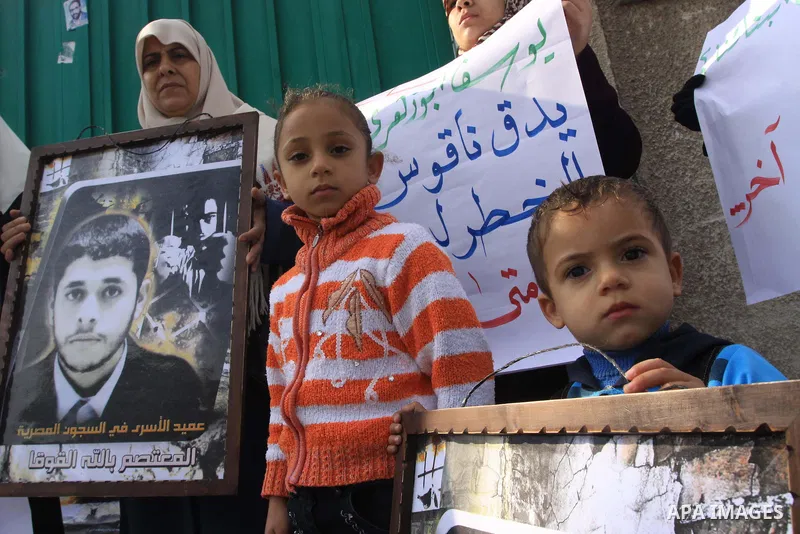 Palestinians hold pictures of their relatives jailed in Egyptian prisons during a protest in Gaza City on Dec 10, 2009 to call for their release. Photo By Mohammed Asad