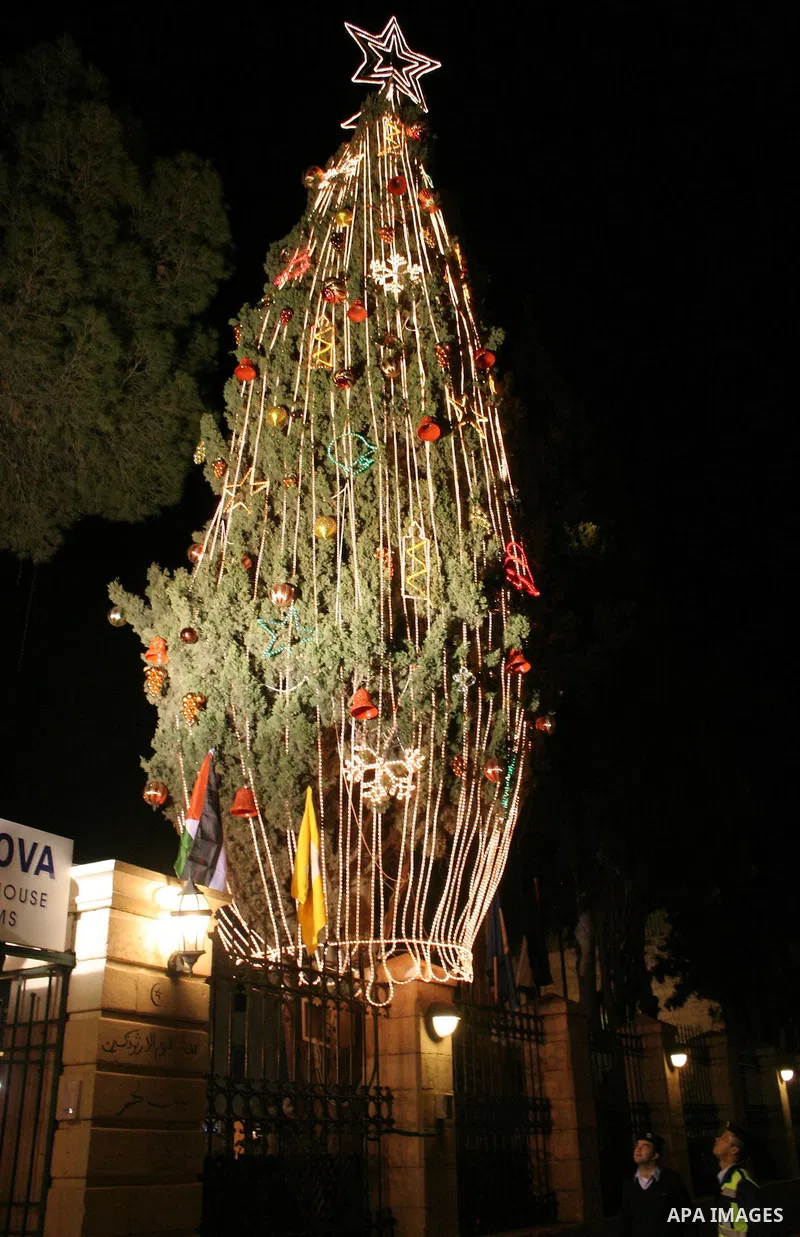 Palestinian Police looking at the tree at Mangar square where a Christmas tree is decorated and lighted by the representative of the Palestinian Authority and the Mayor of Bethlehem, 15 December 2009 in the southern town...