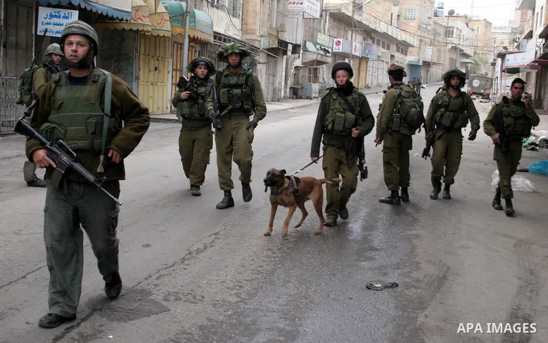 Israeli soldiers guard tens of Israeli settlers and ultra-Orthodox Jews as they pay a visit to the Jewish shrine of Atnaeil Ben Kinaz in a Palestinian neighbourhood in the divided city of Hebron in the occupied West Bank...