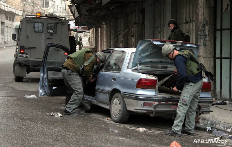 Israeli soldiers guard tens of Israeli settlers and ultra-Orthodox Jews as they pay a visit to the Jewish shrine of Atnaeil Ben Kinaz in a Palestinian neighbourhood in the divided city of Hebron in the occupied West Bank...
